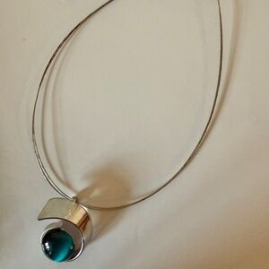 Choker necklace featuring turquoise-blue glass bead in a silver swirl setting